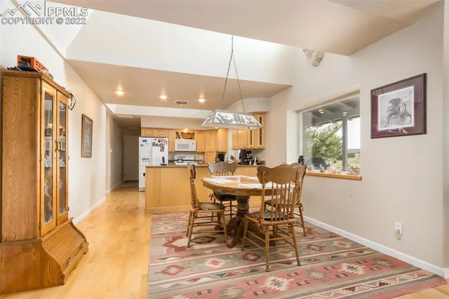 a dining room with wooden floor and large window