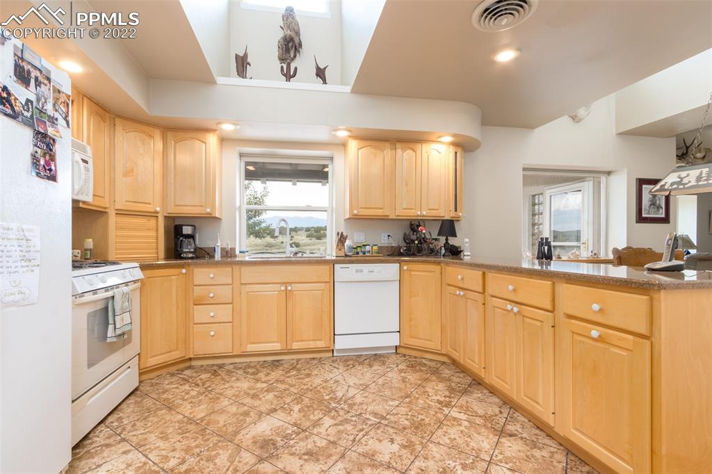 6670 Zercher Road Beulah, CO 81023 - Photo 17 of 41 a large white kitchen with stainless steel appliances granite countertop a stove a sink and a microwave