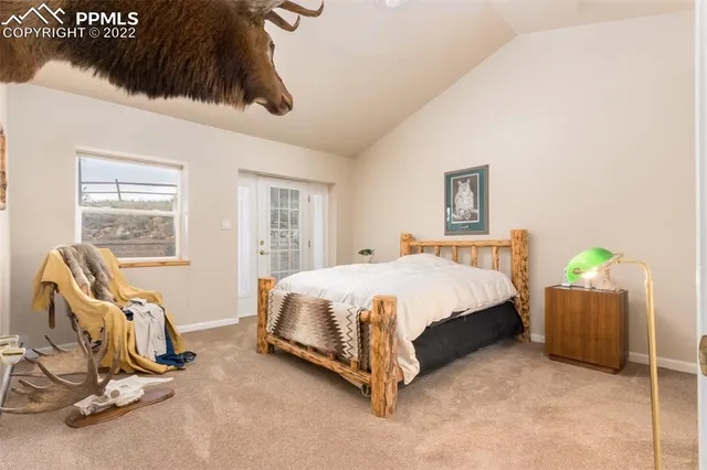 a spacious bedroom with a bed a couch and large window