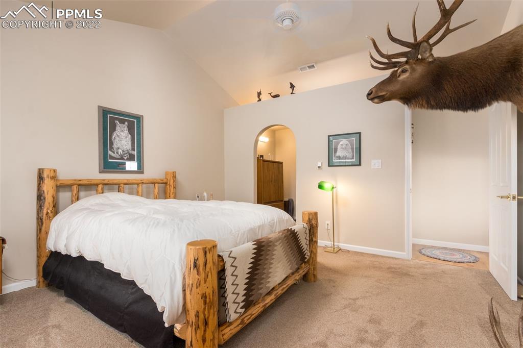 6670 Zercher Road Beulah, CO 81023 - Photo 21 of 41 a bedroom with a bed and a chandelier