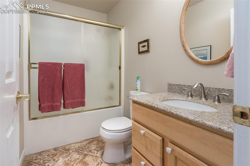 6670 Zercher Road Beulah, CO 81023 - Photo 27 of 41 a bathroom with a granite countertop sink a toilet and a mirror
