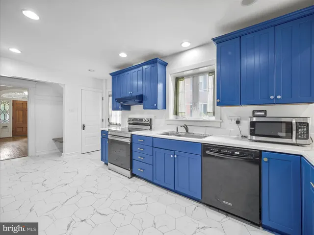 a kitchen with kitchen island granite countertop wooden cabinets stainless steel appliances a sink and a window