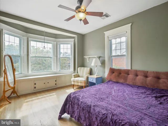 a bedroom with a bed and a large window