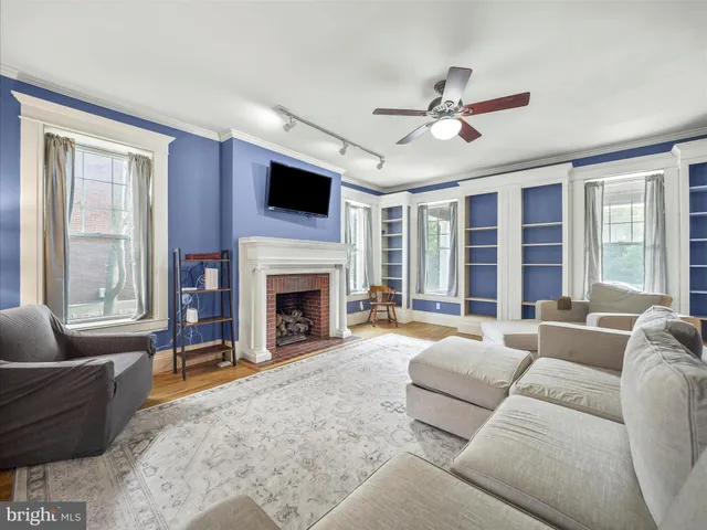 a living room with furniture a fireplace and a large window