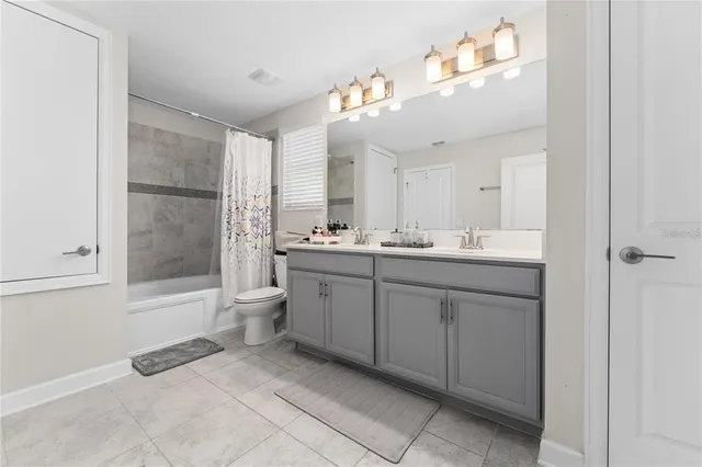 a spacious bathroom with a double vanity sink a large mirror and a bathtub