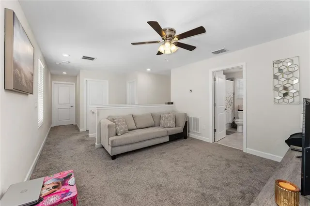 a living room with furniture and a view of kitchen
