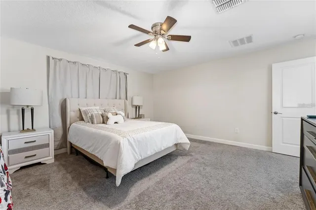 a bed room with a bed and a ceiling fan