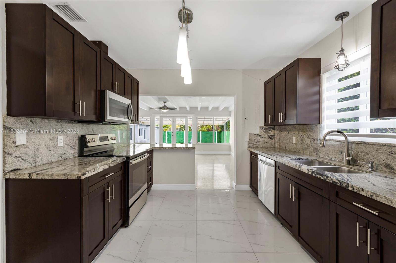 340 Southwest 25th Road Miami, FL 33129 - Photo 12 of 42 a large kitchen with granite countertop a stove sink and cabinets