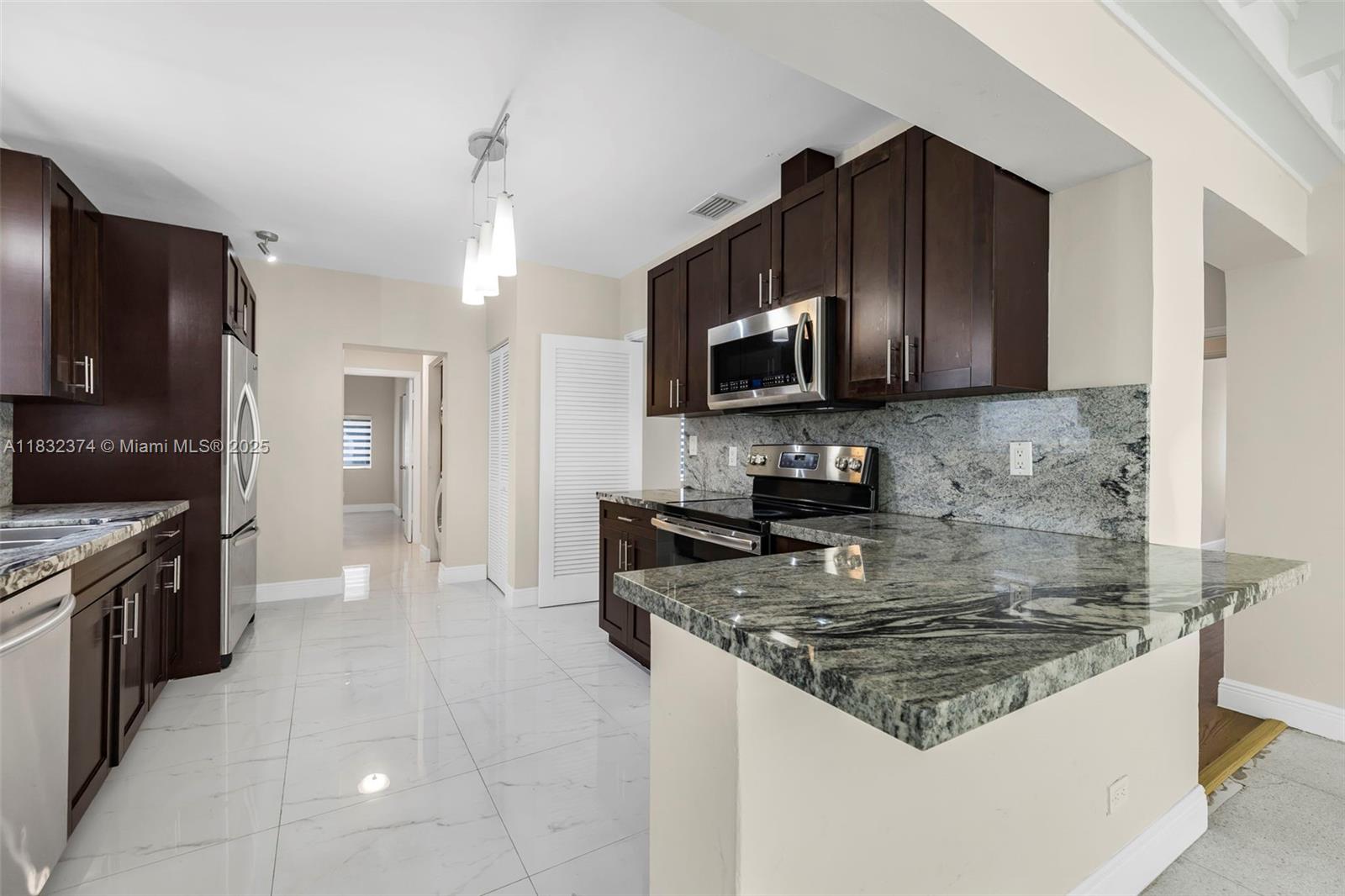 340 Southwest 25th Road Miami, FL 33129 - Photo 15 of 42 a kitchen with a stove a sink and a microwave