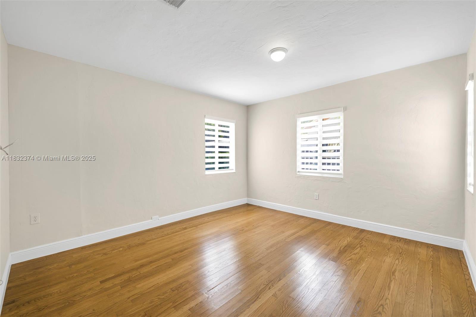 340 Southwest 25th Road Miami, FL 33129 - Photo 19 of 42 an empty room with wooden floor and windows