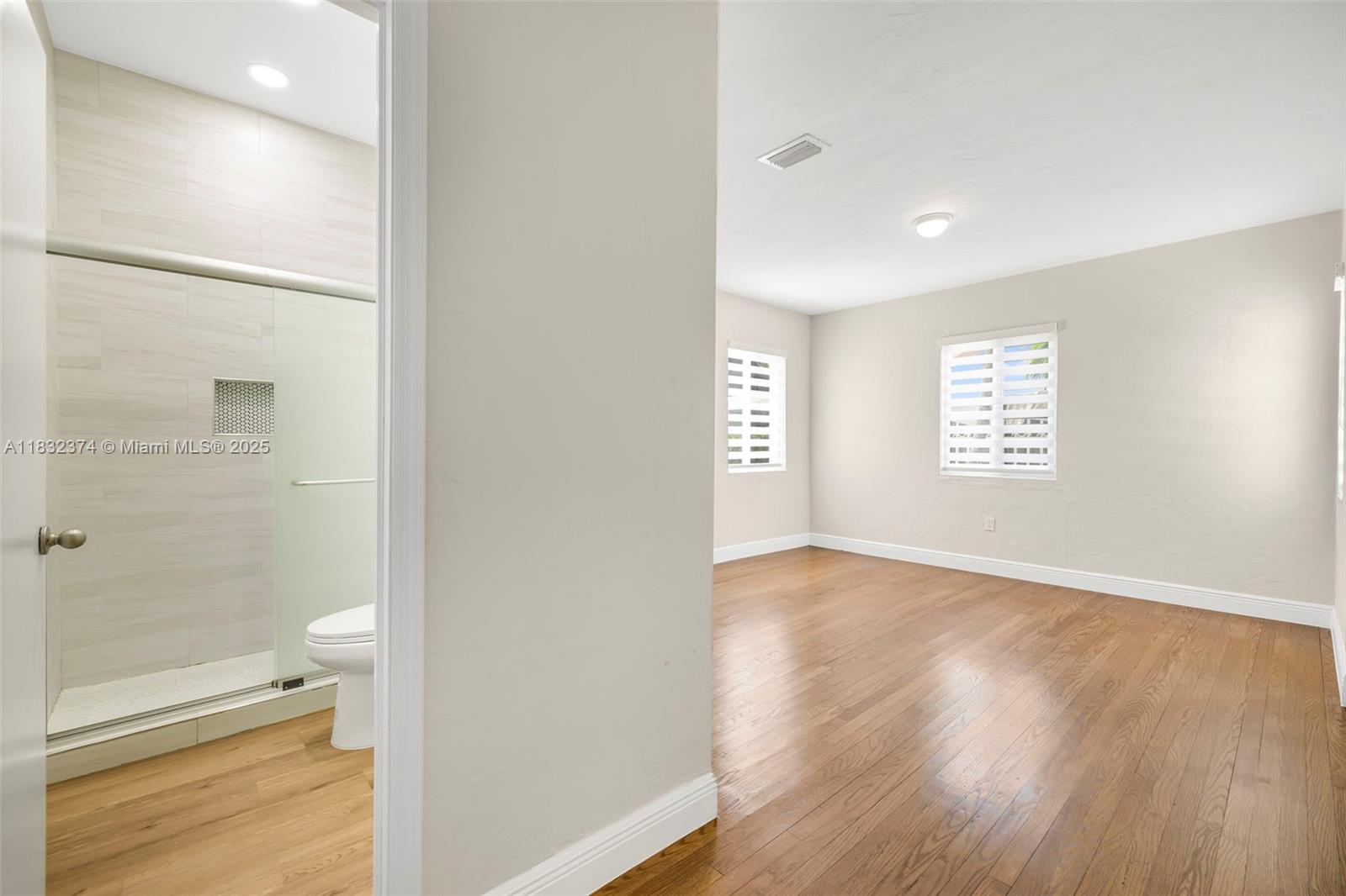 340 Southwest 25th Road Miami, FL 33129 - Photo 20 of 42 a view of an empty room with a window and wooden floor