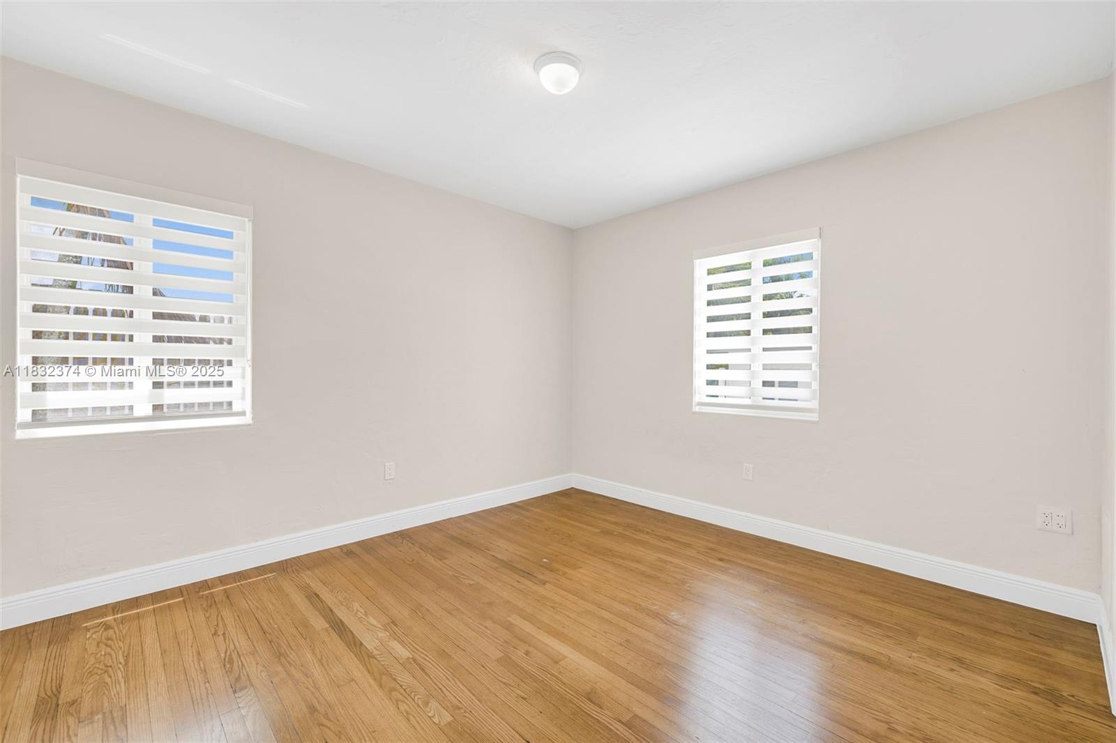 340 Southwest 25th Road Miami, FL 33129 - Photo 25 of 42 an empty room with wooden floor and windows