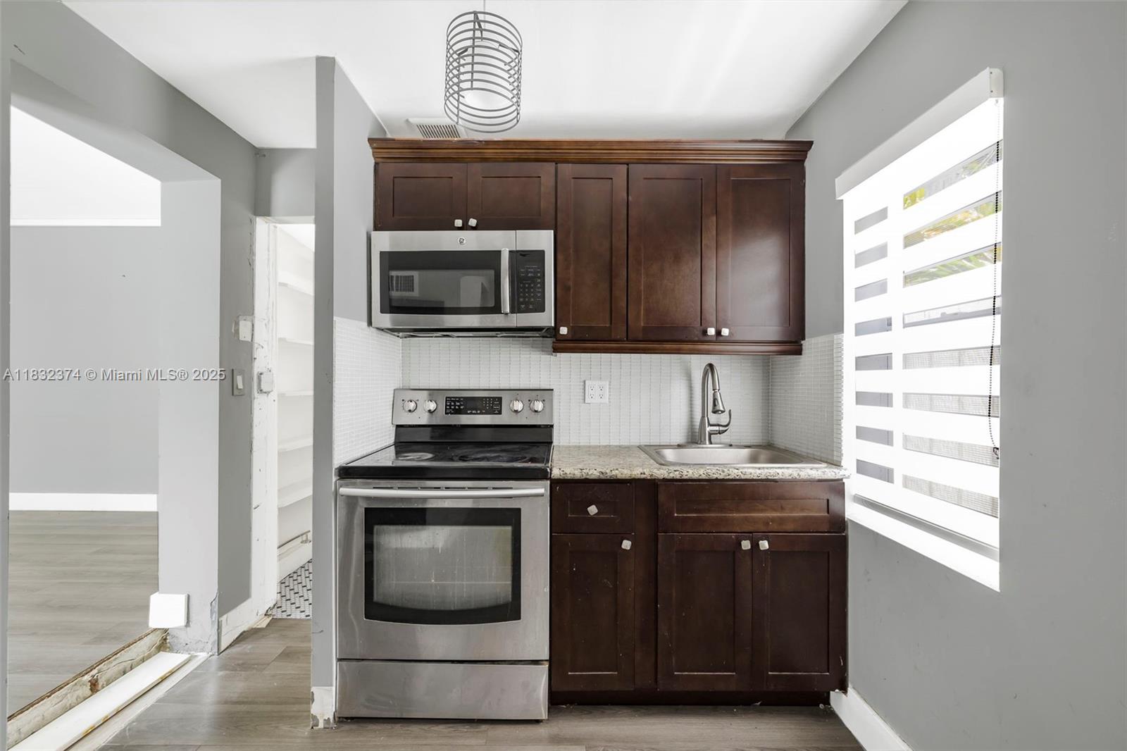 340 Southwest 25th Road Miami, FL 33129 - Photo 38 of 42 a kitchen with granite countertop a stove and a microwave
