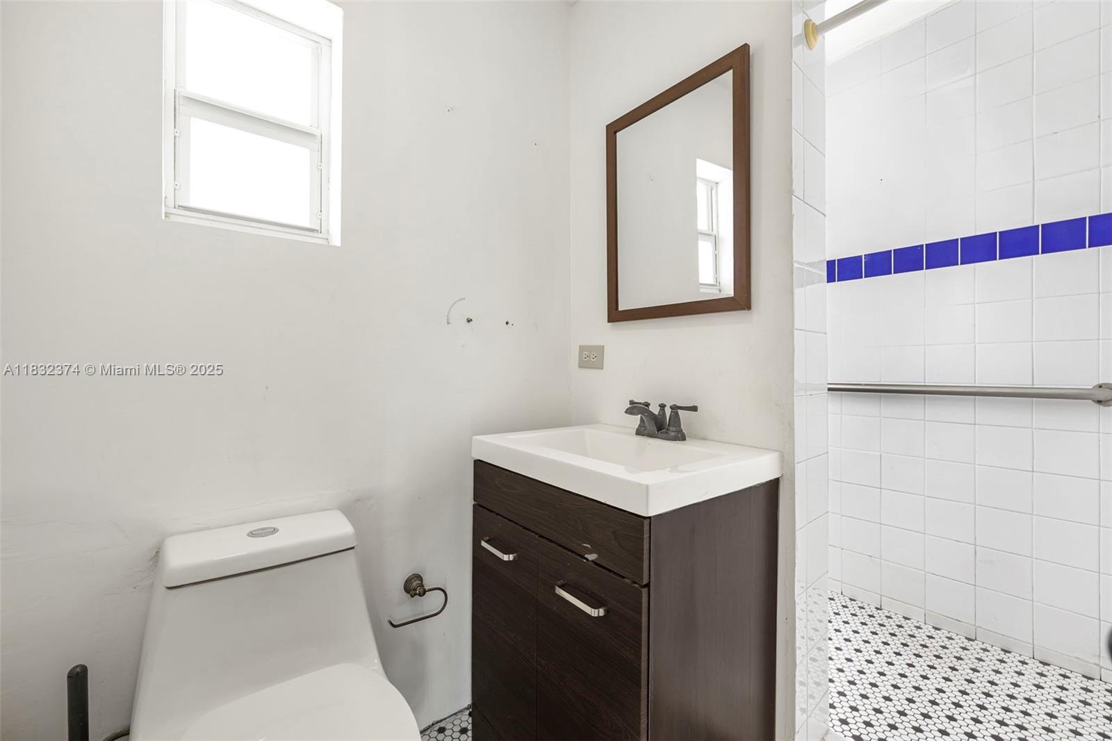 340 Southwest 25th Road Miami, FL 33129 - Photo 39 of 42 a bathroom with a toilet a sink a vanity and mirror