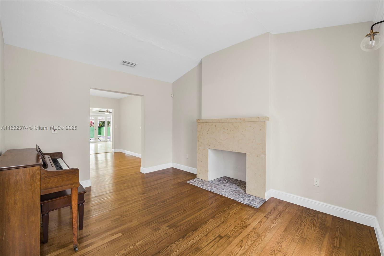 340 Southwest 25th Road Miami, FL 33129 - Photo 9 of 42 a view of empty room with wooden floor and fireplace