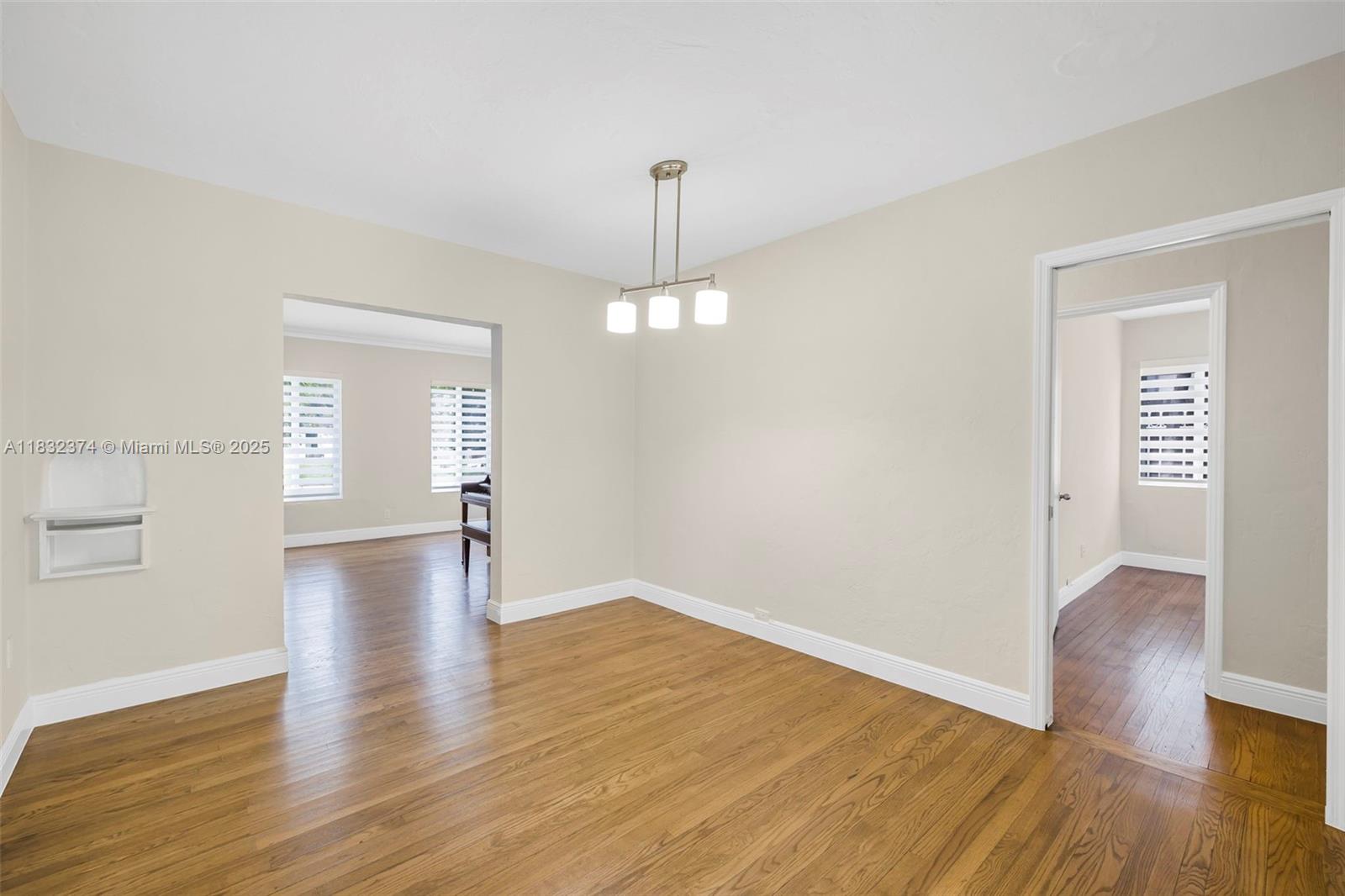 340 Southwest 25th Road Miami, FL 33129 - Photo 10 of 42 a view of an empty room with wooden floor and a window