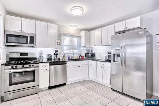 a kitchen with cabinets stainless steel appliances and a window