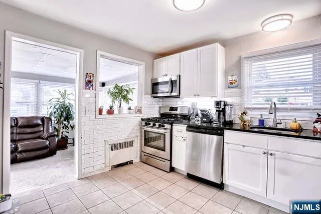 a kitchen with white cabinets and white appliances