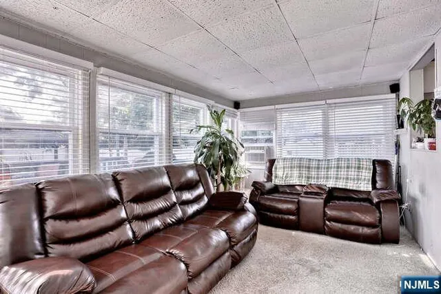 a living room with furniture a flat screen tv and a large window