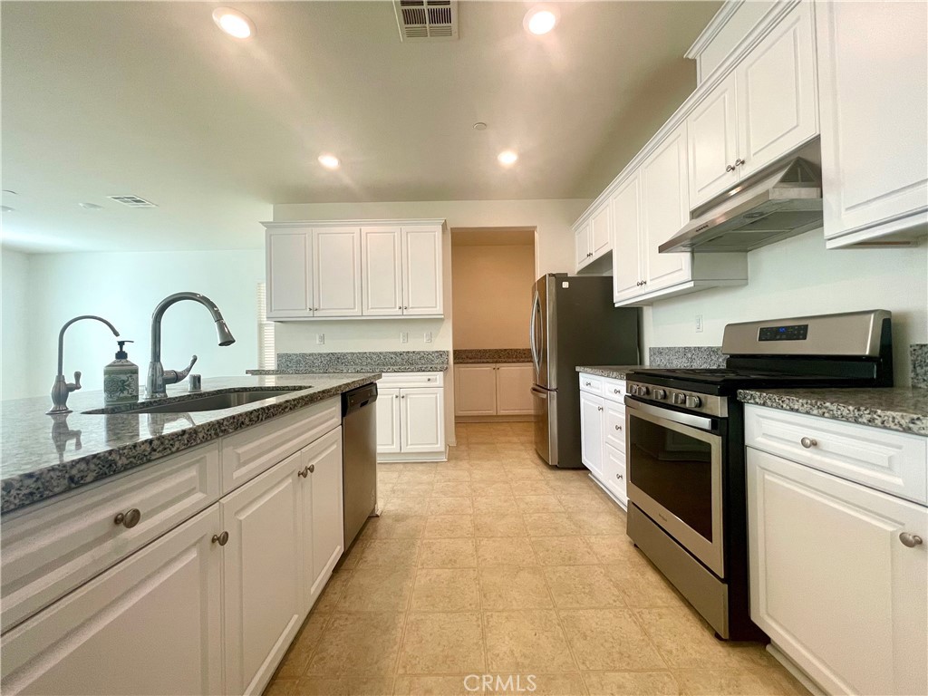 2076 East Bulletin Privado Ontario, CA 91764 - Photo 3 of 20 a kitchen with stainless steel appliances granite countertop a sink a stove and a refrigerator