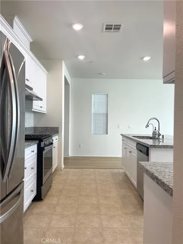 a kitchen with kitchen island granite countertop a sink a counter top space and cabinets
