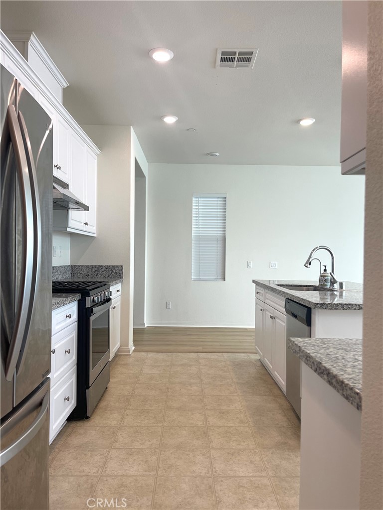 2076 East Bulletin Privado Ontario, CA 91764 - Photo 4 of 20 a kitchen with stainless steel appliances granite countertop a sink stove and refrigerator