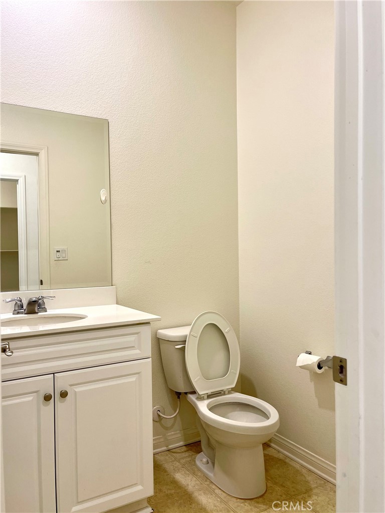 2076 East Bulletin Privado Ontario, CA 91764 - Photo 6 of 20 a bathroom with a toilet sink vanity and mirror