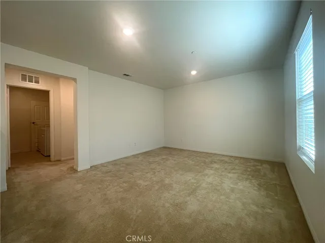 a view of a big room with a chandelier fan and windows