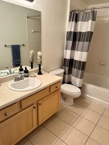 a bathroom with a sink a toilet a mirror and shower