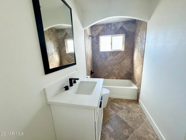 a bathroom with a toilet a sink and mirror