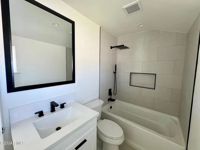 a bathroom with a sink mirror bathtub and toilet