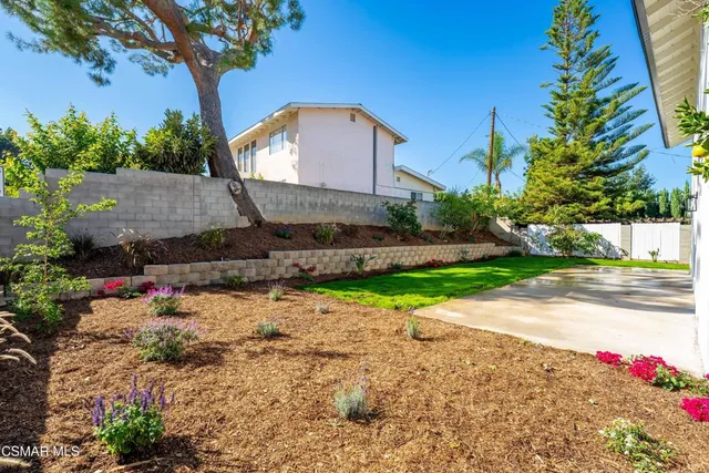 a front view of a house with a yard and a garden