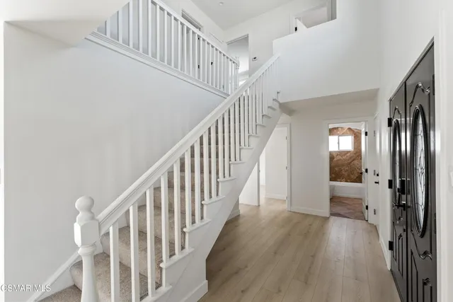 a view of staircase with wooden floor and white walls