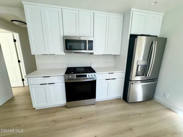 a kitchen with a stainless steel appliances and a refrigerator