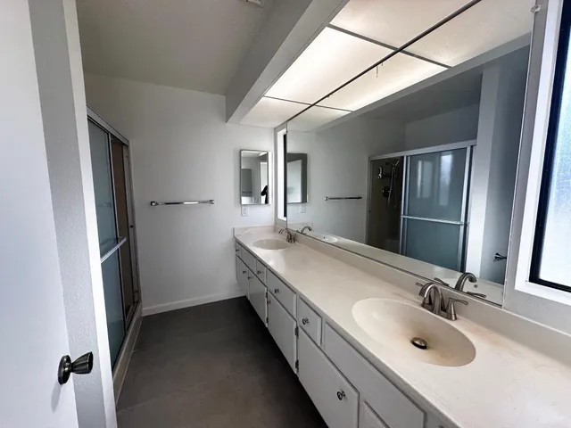 a bathroom with a double vanity sink and mirror