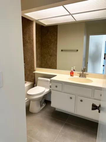 a bathroom with a toilet sink and mirror