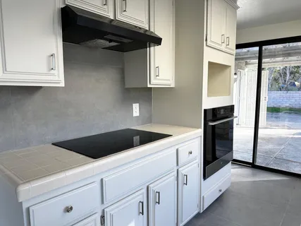 a kitchen with white cabinets and white appliances