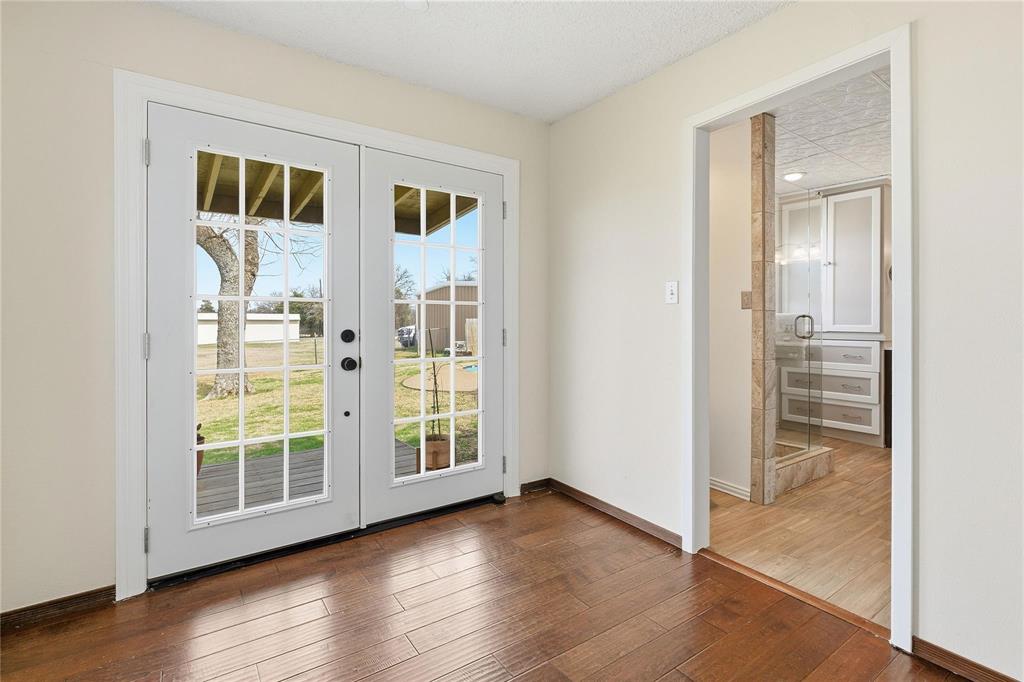 9213 Wilson Road Pilot Point, TX 76258 - Photo 20 of 36 French doors with divided lites open to an exterior porch and green landscape