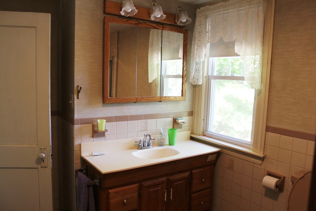 232 Gates Pond Road Berlin, MA 01503 - Photo 17 of 25 a bathroom with a sink a mirror and a window