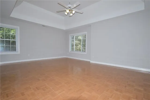 an empty room with a window and a ceiling fan