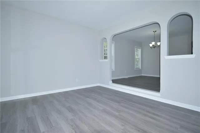 an empty room with wooden floor and mirror