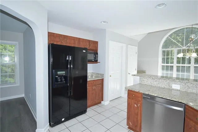 a kitchen with granite countertop a refrigerator and a sink