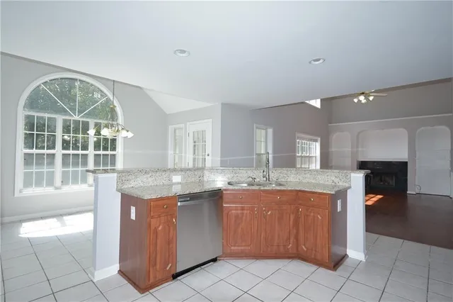 a kitchen with granite countertop a stove a sink and a microwave