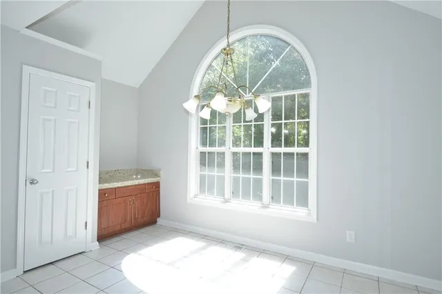 an empty room with large windows and outdoor seating