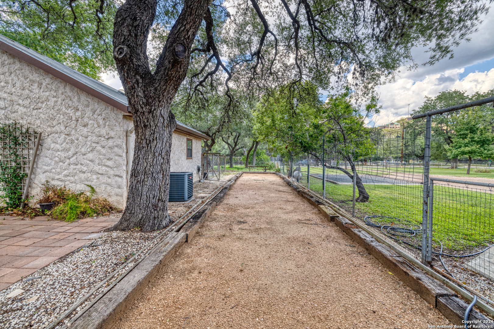 1242 River Road Concan, TX 78838 - Photo 31 of 42 a view of a house with a backyard and a large tree
