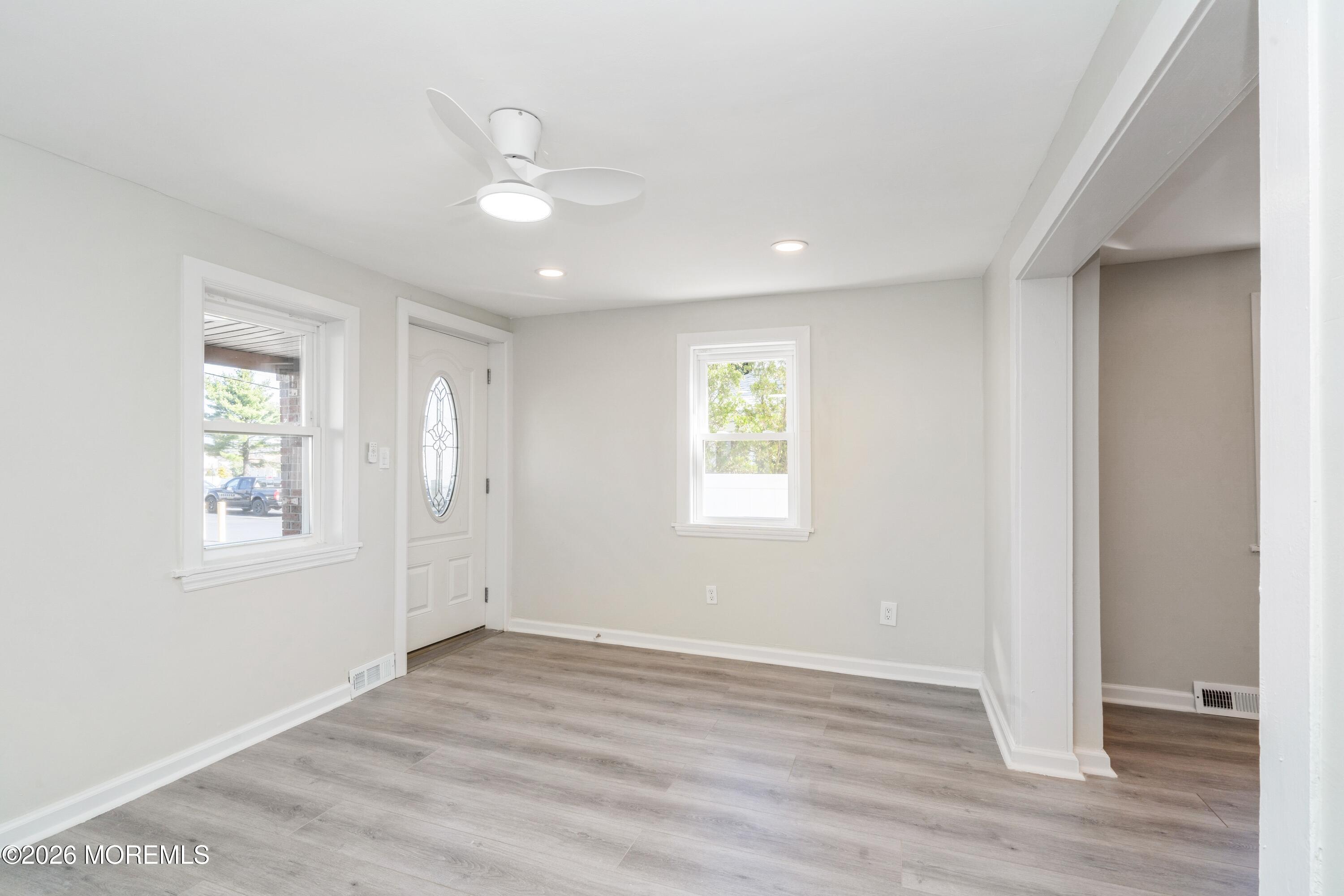 21 Mathiasen Place, Unit A Matawan, NJ 07747 - Photo 3 of 12 an empty room with wooden floor and windows