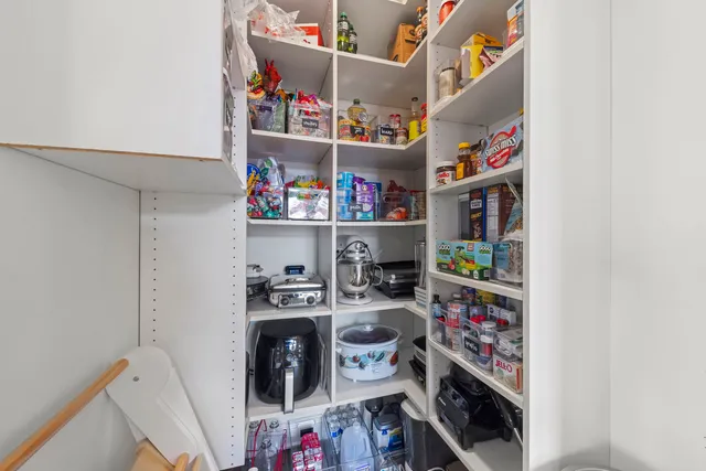 a bedroom with a bed chair and two windows
