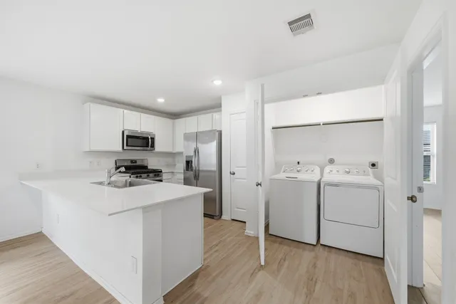 a kitchen with appliances a sink and cabinets
