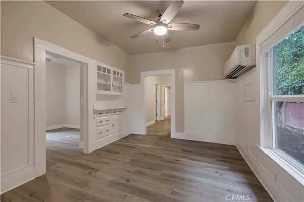 a view of empty room with wooden floor and fan