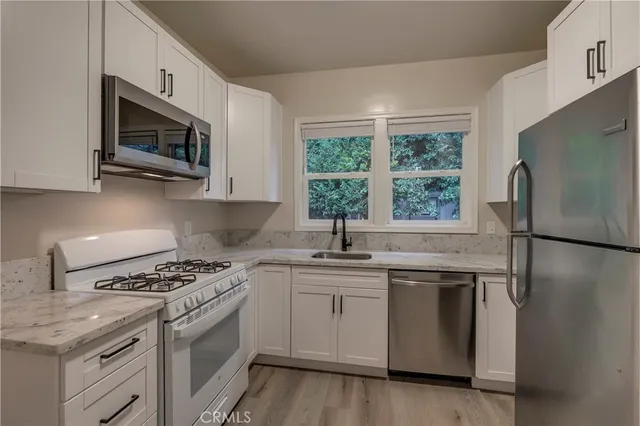 a kitchen with stainless steel appliances granite countertop a stove a sink and a microwave